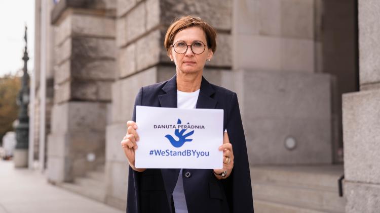 Bettina Stark-Watzinger hält ein Schild mit der Aufschrift "Danuta Peradnia - We Stand By You!"